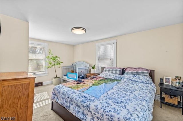 bedroom featuring light colored carpet and baseboards