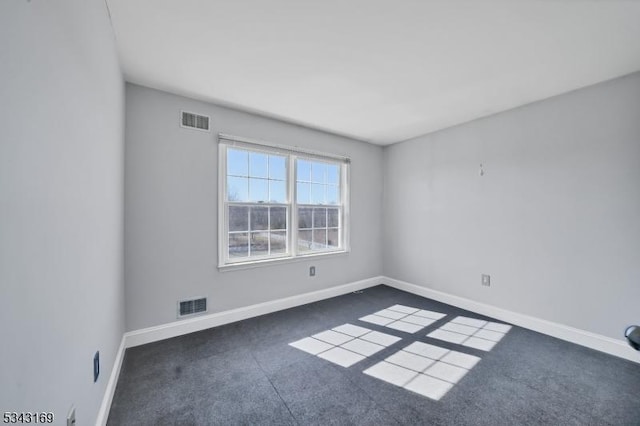 carpeted spare room featuring baseboards and visible vents