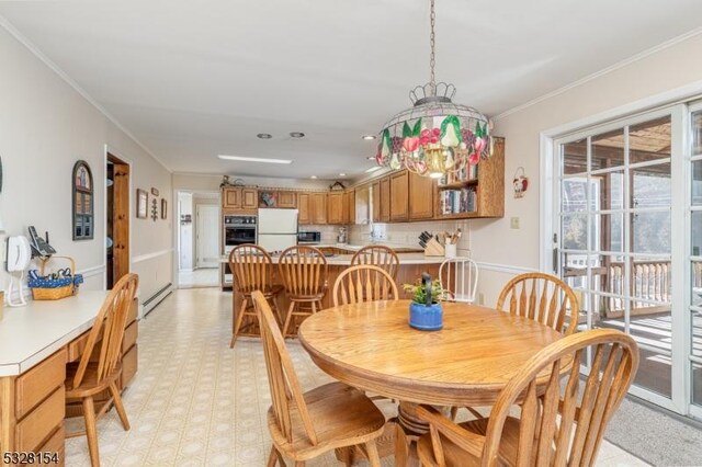 dining area featuring baseboard heating, light floors, and crown molding