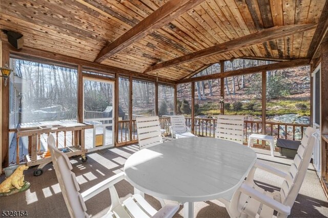 sunroom / solarium featuring a wealth of natural light, wooden ceiling, and vaulted ceiling with beams