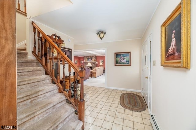foyer with light tile patterned floors, stairway, a baseboard heating unit, and baseboards