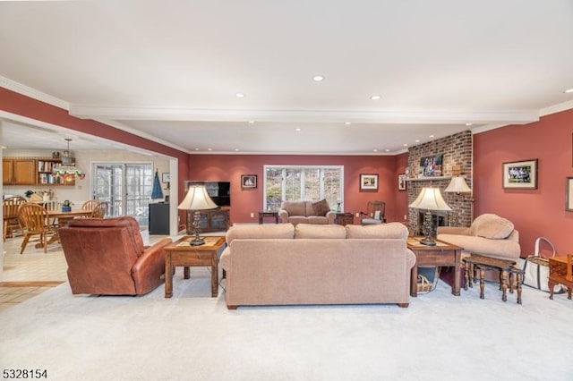 living room with beamed ceiling, ornamental molding, a fireplace, and light carpet