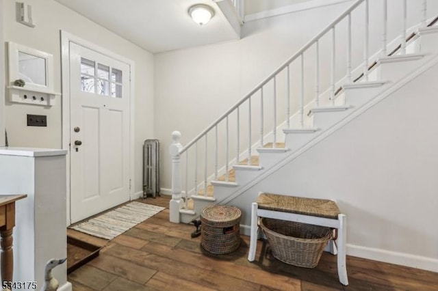 entrance foyer featuring stairway, baseboards, and wood finished floors