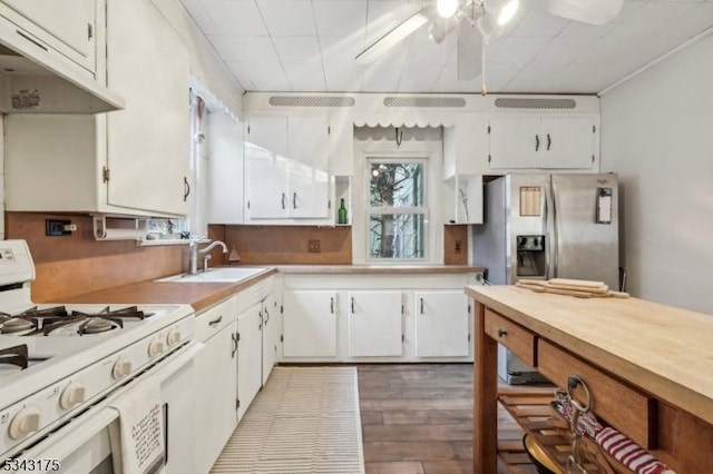 kitchen with a sink, gas range gas stove, white cabinets, and light countertops