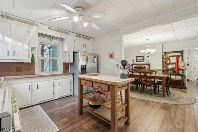 kitchen with white cabinetry, wood finished floors, stainless steel fridge with ice dispenser, and light countertops