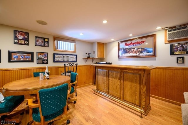 bar with a wainscoted wall, light wood-style flooring, recessed lighting, wooden walls, and a dry bar