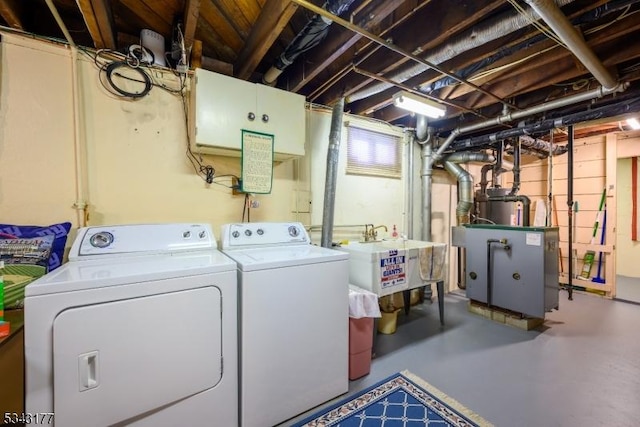 laundry room with washer and dryer, laundry area, water heater, and a sink