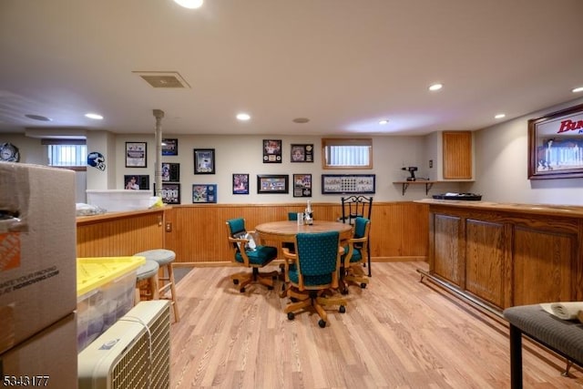 dining room with light wood-type flooring, visible vents, recessed lighting, and wainscoting