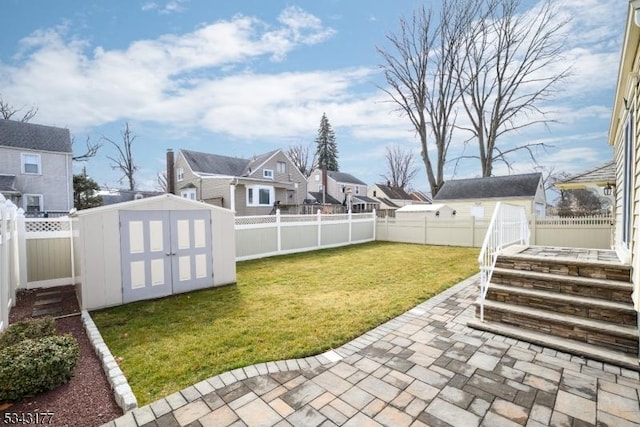 view of yard with a storage shed, a fenced backyard, an outdoor structure, and a patio