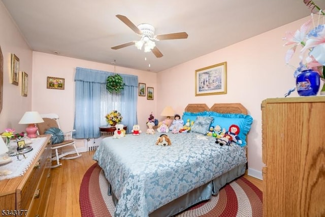 bedroom with baseboards, ceiling fan, and wood finished floors