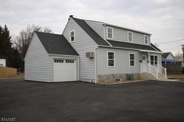 view of front of home with a garage, fence, driveway, and a shingled roof