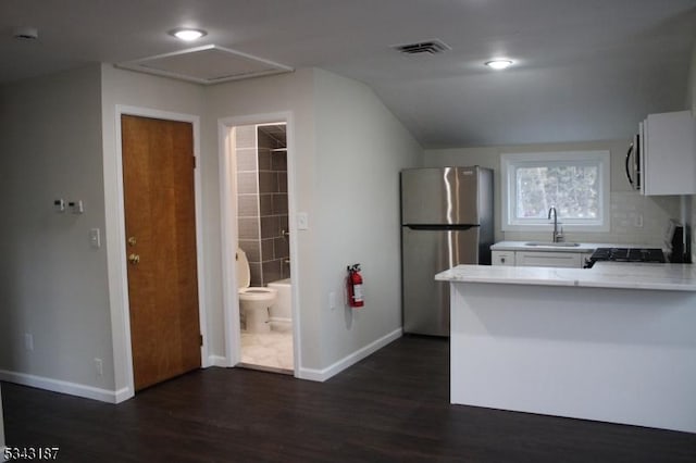 kitchen with a sink, dark wood finished floors, freestanding refrigerator, light countertops, and baseboards