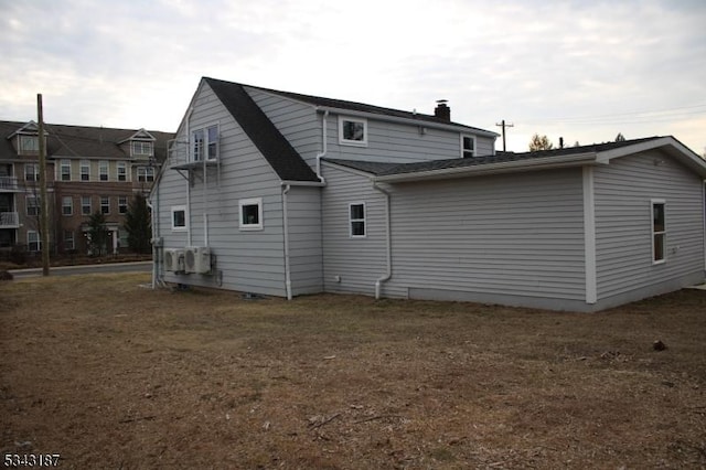 back of house featuring a chimney