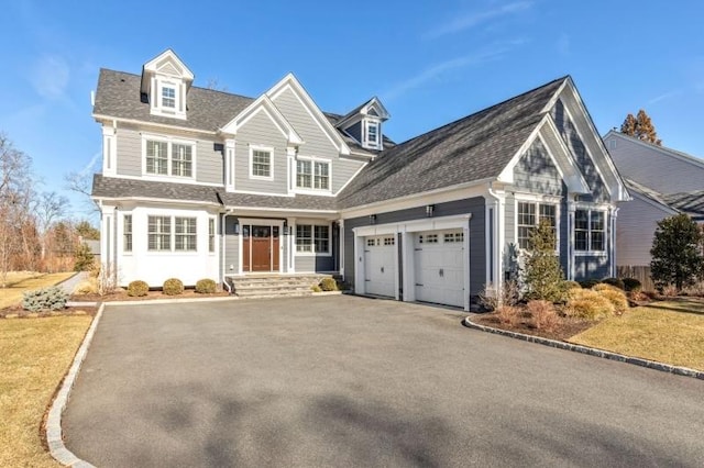 view of front of house with aphalt driveway, an attached garage, and a shingled roof