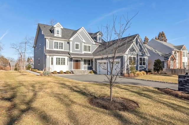 view of front of home featuring a front lawn, an attached garage, fence, and driveway