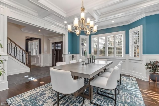 dining area featuring ornamental molding, an inviting chandelier, and wood finished floors