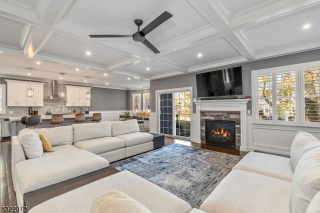 living room with wood finished floors, beamed ceiling, a ceiling fan, and coffered ceiling