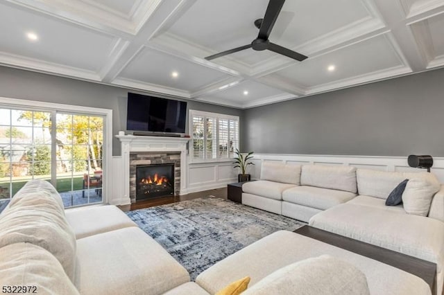 living room featuring beam ceiling, a fireplace, ceiling fan, and wood finished floors