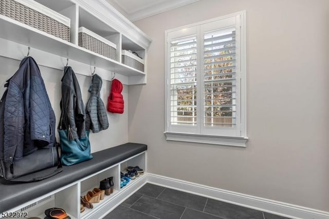 mudroom featuring baseboards, dark tile patterned flooring, and crown molding