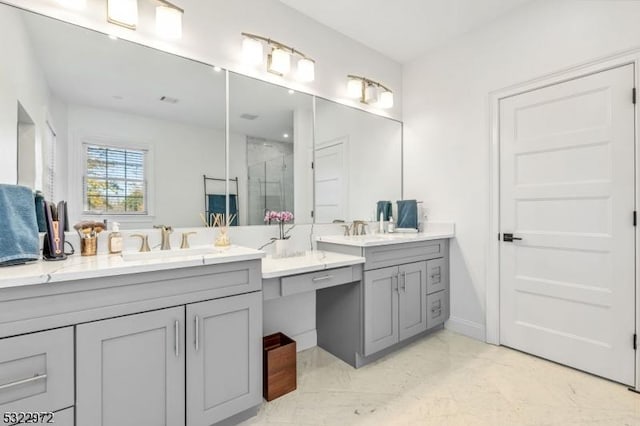 bathroom featuring marble finish floor, a stall shower, two vanities, and a sink