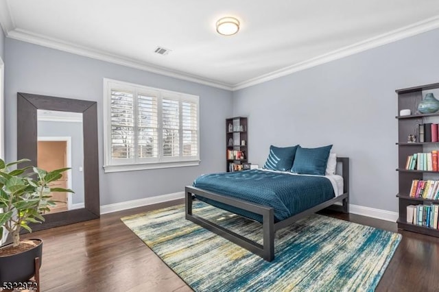 bedroom with baseboards, wood finished floors, visible vents, and ornamental molding