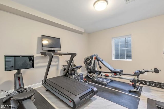 workout room featuring baseboards and wood finished floors