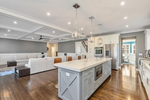 kitchen with stainless steel appliances, dark wood-type flooring, a kitchen island, and coffered ceiling