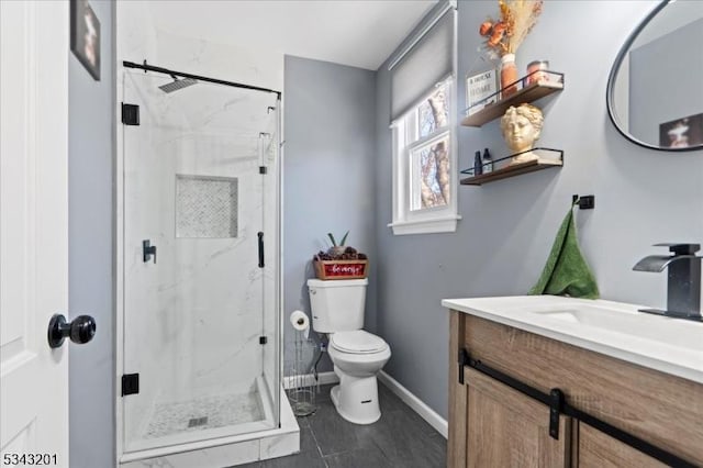 full bath with a marble finish shower, toilet, vanity, and baseboards