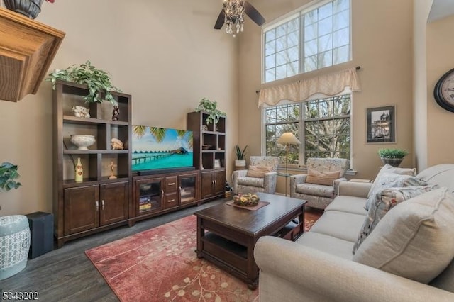 living area featuring wood finished floors, a high ceiling, and ceiling fan