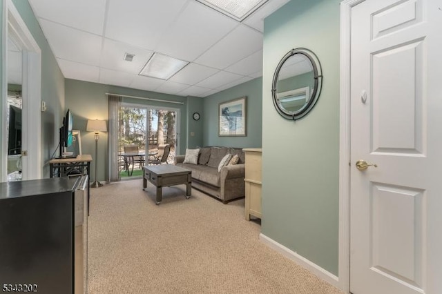 living room with baseboards, a paneled ceiling, light carpet, and visible vents