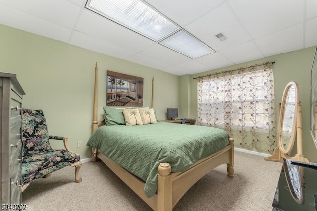 bedroom featuring a drop ceiling, carpet flooring, baseboards, and visible vents