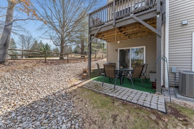 view of yard with central AC unit, fence, and a patio