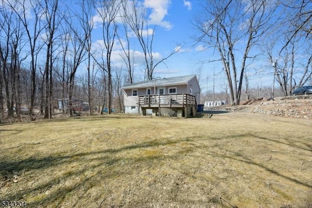 back of property featuring a deck and a lawn