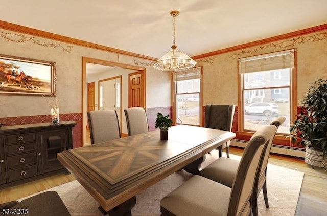 dining space with light wood finished floors, a notable chandelier, baseboard heating, and crown molding