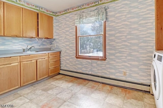 kitchen featuring wallpapered walls, washer / dryer, baseboard heating, and a sink