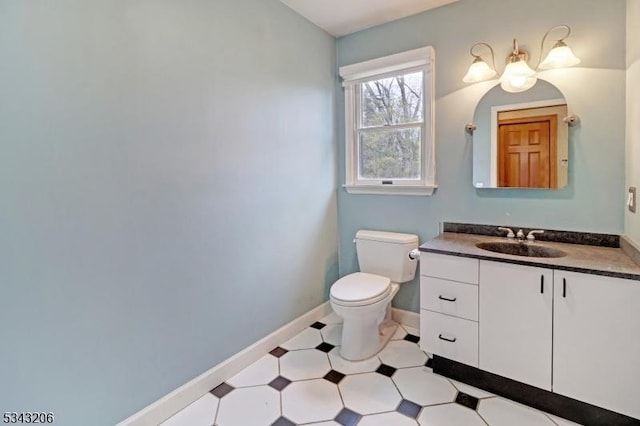 bathroom with vanity, toilet, and baseboards