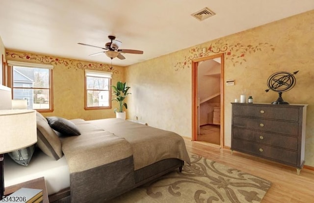 bedroom featuring visible vents, a ceiling fan, and wood finished floors