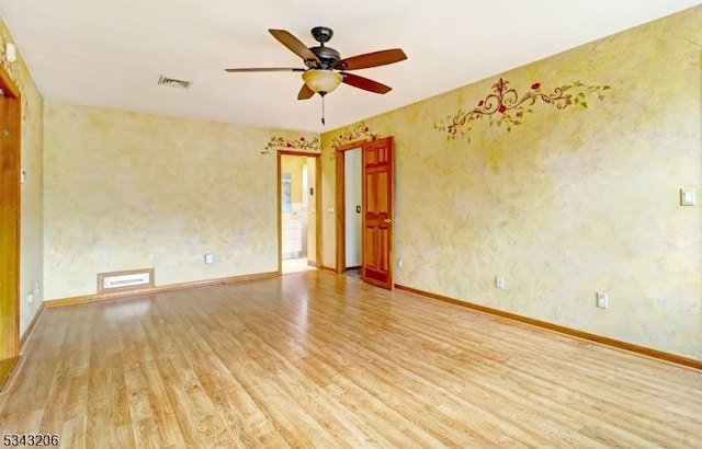 unfurnished room featuring a ceiling fan, wood finished floors, visible vents, and baseboards