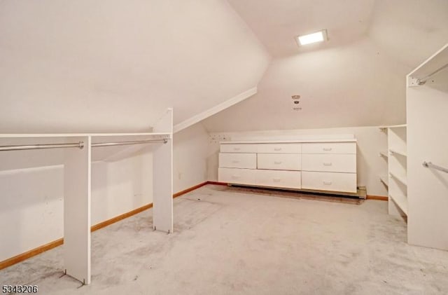 spacious closet featuring light colored carpet and vaulted ceiling