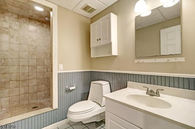 full bath featuring visible vents, a wainscoted wall, tile patterned flooring, a shower stall, and toilet