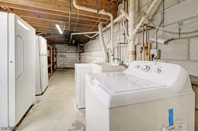 laundry area with laundry area, independent washer and dryer, and a sink