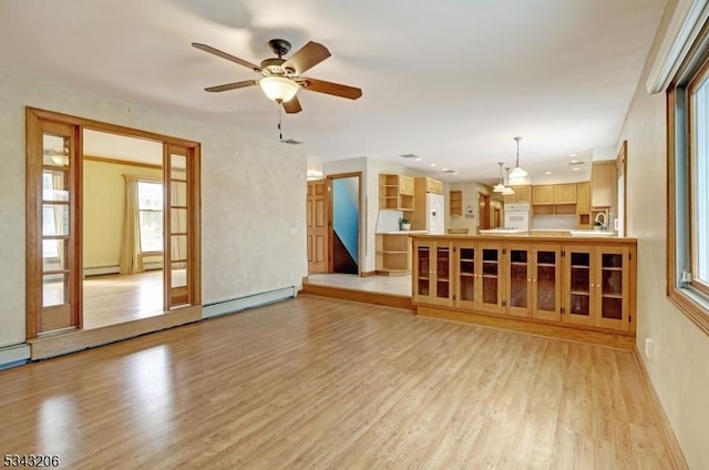 unfurnished living room featuring a baseboard heating unit, light wood-type flooring, and ceiling fan