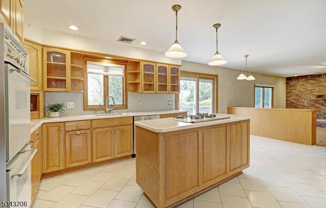 kitchen with white appliances, visible vents, open shelves, a sink, and a center island