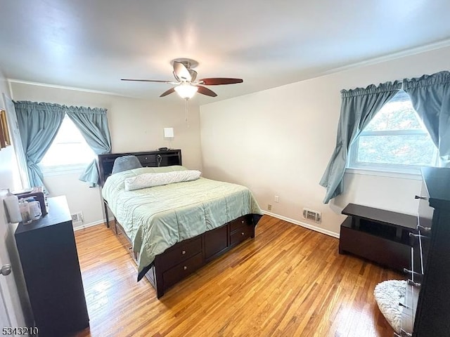 bedroom featuring baseboards, visible vents, and light wood finished floors