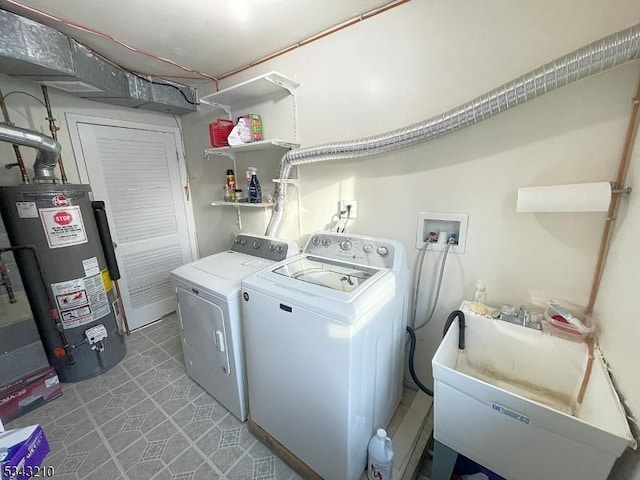 washroom featuring washer and clothes dryer, gas water heater, light floors, laundry area, and a sink