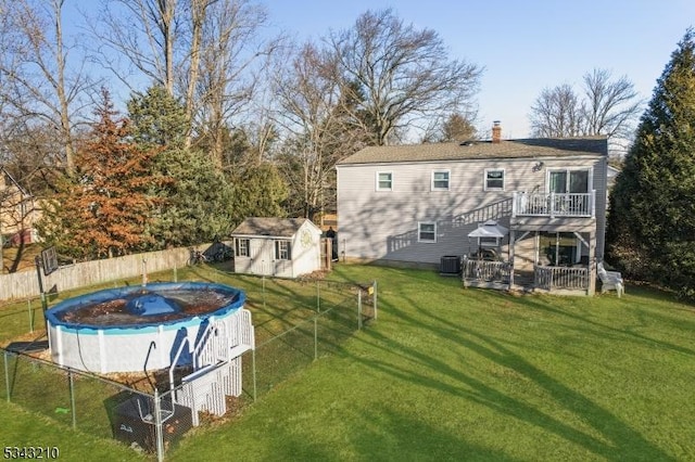 exterior space featuring a fenced in pool, fence, cooling unit, a deck, and an outdoor structure