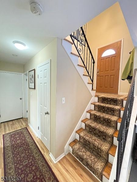 stairs with baseboards and wood finished floors