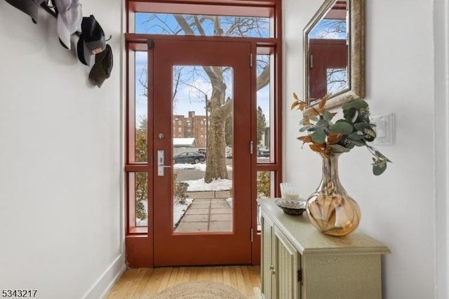 doorway to outside with baseboards and light wood-type flooring