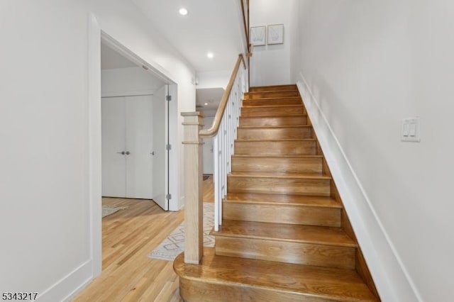 stairs featuring recessed lighting and wood finished floors