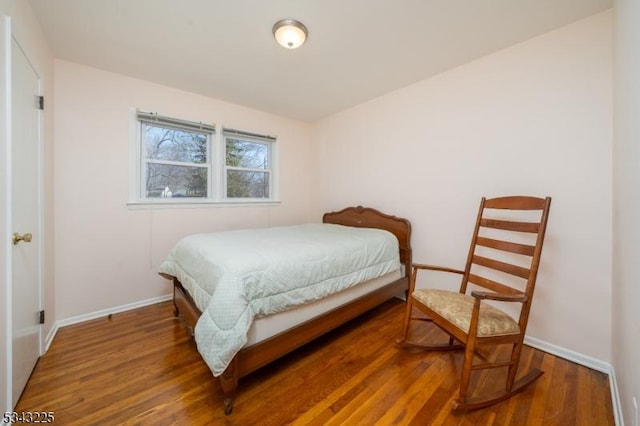 bedroom with wood finished floors and baseboards